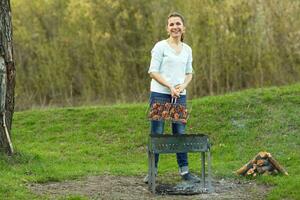 Young girl preparing food on grill photo