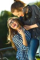 Two playful girls having fun outdoors at sunset light photo