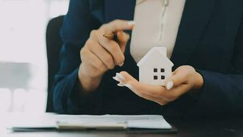 Female woman hands holding home model, small miniature white toy house. Mortgage property insurance dream moving home and real estate concept video