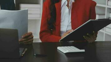 Financial analysts analyze business financial reports on a digital tablet planning investment project during a discussion at a meeting of corporate showing the results of their successful teamwork. video