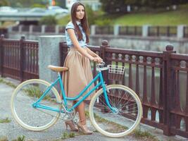 joven mujer hermosa, elegantemente vestida con bicicleta foto