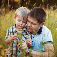 Happy father and his baby son having fun in the park photo