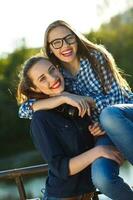 dos juguetón joven niña teniendo divertido al aire libre a puesta de sol ligero foto