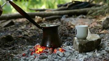 Image of Turkish coffee cooked on red coals, the coffee made in the forest will be put into the cup standing on the stone video