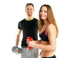 Athletic man and woman with dumbbells on the white photo