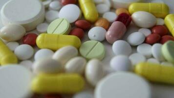 Macro shot of prescription drugs on a reflective surface, the image of different drugs falling on a rotating floor, used in the treatment of diseases video