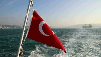 The image of the flag waving in the wind on the end of the ship going through the Bosphorus in Istanbul, a boat view of the city established on the seashore video