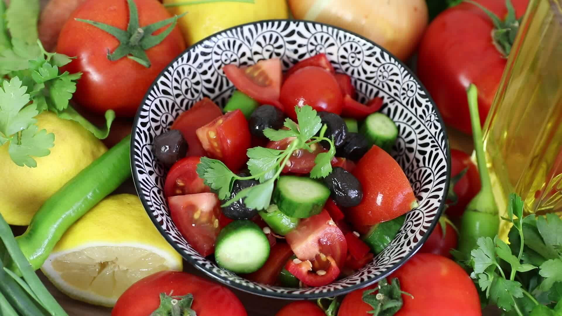 Adding Olive Oil To The Salad Standing Among The Vegetables Salad 