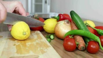 corte tablero mientras el cortar limón desde vegetales acostado en el mesa, un hombre el cortar ingredientes a hacer un ensalada video