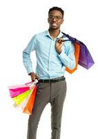 Happy african american man holding shopping bags on white background photo