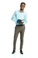 Happy african american college student with books in his hands  standing on white photo