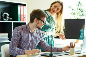 Beautiful young woman and man working from home photo