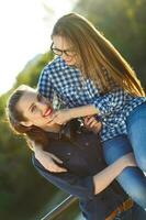 Two playful girls having fun outdoors at sunset light photo