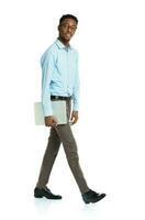 Happy african american college student with laptop standing on white photo