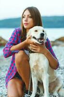 mujer con un perro en un caminar en el playa foto