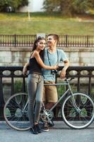 contento Pareja - hombre y mujer con bicicleta en el parque al aire libre foto