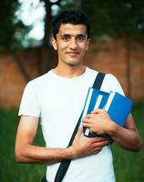 árabe masculino estudiante con libros al aire libre foto