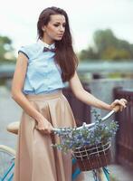 joven mujer hermosa, elegantemente vestida con bicicleta foto