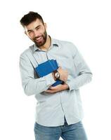 Young bearded smiling man with books in hands on white photo