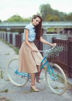 Young beautiful, elegantly dressed woman with bicycle photo