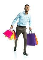 Happy african american man holding shopping bags on white background photo