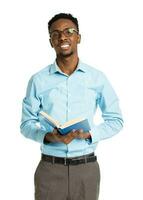 Happy african american college student with books in his hands  standing on white photo