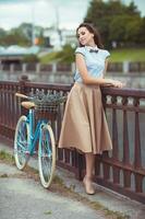 Young beautiful, elegantly dressed woman with bicycle photo