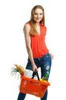 Young caucasian woman with assorted grocery products in shopping basket isolated on white photo