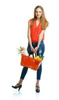 Happy woman holding a basket full of healthy food. Shopping photo