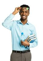 Happy african american college student with books and bottle of water in his hands standing on white photo