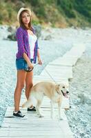 Woman with a dog on a walk on the beach photo