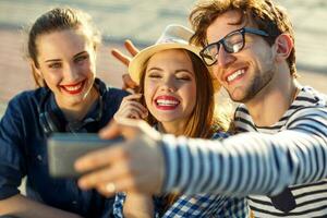 Smiling friends making selfie outdoors photo