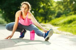 joven mujer calentamiento arriba antes de corriendo foto