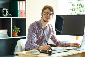 Young artist drawing something on graphic tablet photo