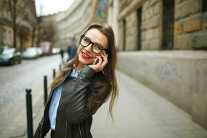 Businesswoman on cellphone walking down the street while talking on smart phone photo