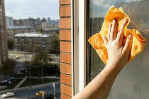 hand wipes open street window at home with rag photo