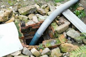 corrugated hose pumping out outdoor septic tank photo