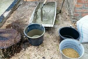 making concrete in trough in backyard in village photo