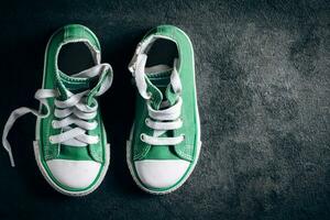 Green sneakers on the black background photo