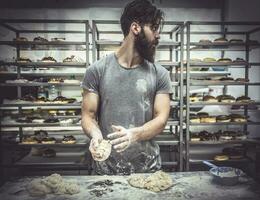 Man in kitchen preparing donuts photo