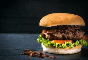 hamburguesa de cerca en oscuro antecedentes foto