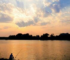 Man fishing over the sunset photo