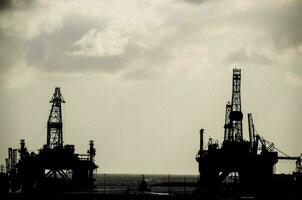 Oil Drilling Rig Silhouette over a Cloudy Sky photo