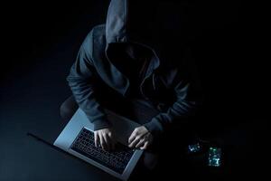 Internet hacker sitting at personal computer laptop tablet photo