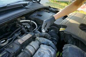 Mechanic checking the engine. Car service, mechanic repairing the engine. Worker inspecting car engine inside. photo