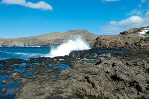 Large waves crashing against the rocks in the ocean photo