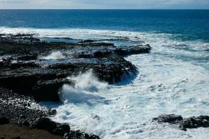 Large waves crashing against the rocks in the ocean photo