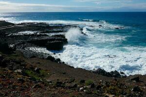 Large waves crashing against the rocks in the ocean photo