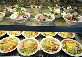 Assortment of salads for sale in the cafeteria photo