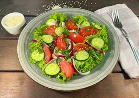 Salad of fresh tomatoes and cucumbers in a bowl photo